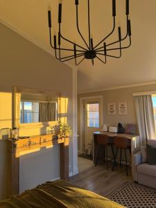 a bedroom with a chandelier and a living room at Mörk Superior Cottages in Hvammstangi