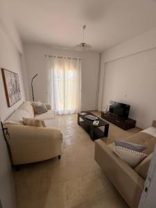 a living room with two couches and a television at Methoni Joanna House in Methoni