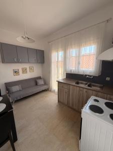 a kitchen and living room with a couch and a stove at Methoni Joanna House in Methoni