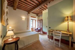 a bedroom with a bed and a desk with a lamp at PODERE BELLARIA 18&2, Emma Villas in Rapolano Terme +71 photos