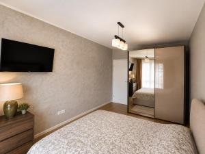 a bedroom with a bed and a television on the wall at Magda's Apartments in Braşov