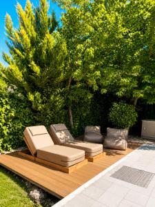 a couple of lounge chairs sitting on a wooden deck at Villa Magnifica - Private Pool, Elevator & Sea View in Paliouri