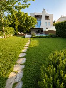 a path in the grass in front of a house at Villa Magnifica - Private Pool, Elevator & Sea View in Paliouri