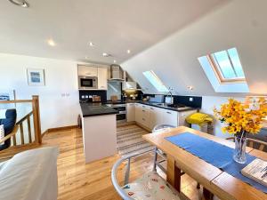 a kitchen and living room with a table and a dining room at Apartment 19 in Downderry