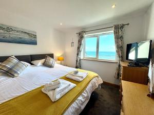 a bedroom with a bed and a television and a window at Apartment 19 in Downderry