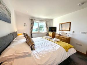 a bedroom with a large bed and a television at Apartment 19 in Downderry
