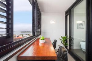 a dining room with a table and a large window at Sunset on the Esplanade in Newcastle
