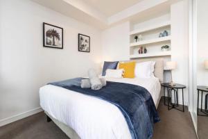 a bedroom with a large white bed in a room at Sunset on the Esplanade in Newcastle +12 photos
