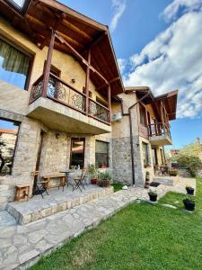 a large house with a balcony and a patio at Rupchini Houses in Bansko