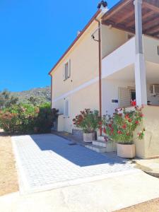 a building with two potted plants in front of it at casa oleandri in Golfo Aranci