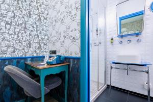 a bathroom with a blue table and a shower at Hôtel Crayon Rouge - Louvre Palais Royal in Paris