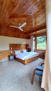 a bedroom with a bed and a wooden ceiling at Himalayan Hideaway Homestay in Kasol