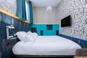 a bedroom with a large bed with white pillows at Hôtel Crayon Rouge - Louvre Palais Royal in Paris +64 photos