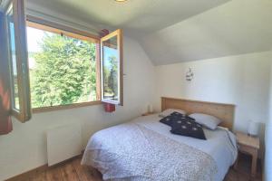 a bedroom with a bed and a large window at Chalet MÖKI accès piscine sauna in Les Déserts