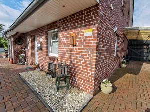 a brick building with a chair in front of it at Ferienhaus Moorspatz, 95143 in Rhauderfehn