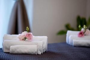 two white towels with pink roses on top of them at Flavia's House in Gaggi