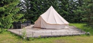 a tent sitting on a wooden deck in a field at Kempingas Prie Vencavų malūno in Viencavai