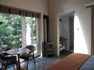 a bedroom with a bed and a table and chairs at ForRest Suites in Ermelo