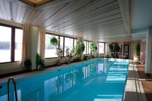 a swimming pool in a building with windows at Hotel Ivalo in Ivalo