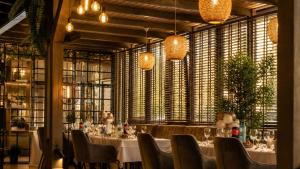 a dining room with tables and chairs and windows at Hotel Restaurant Alesia in Corunca