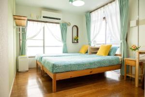 a bedroom with a bed in a room with blue curtains at Tokyo Candle house in Tokyo