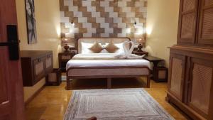 a bedroom with a large bed with a large headboard at ECHO Knuckles Nature Resort in Hunnasgiriya