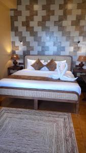 a bedroom with a bed with white sheets and pillows at ECHO Knuckles Nature Resort in Hunnasgiriya +50 photos