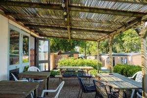 a patio with tables and chairs under a wooden pergola at A View for Two in Tarchamps