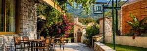 a patio with a table and chairs and flowers at Hôtel La Vigneraie in Levens