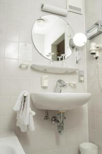 
a bathroom with a sink, mirror, and toilet at Hotel zum Ochsen in Ehingen
