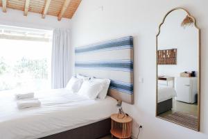 a bedroom with a bed with a mirror and a window at Vale das Estrelas in São Teotónio +192 photos