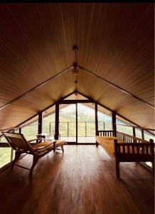 a large room with two benches and a large window at ECHO Knuckles Nature Resort in Hunnasgiriya