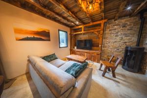 a living room with a couch and a tv at Châlet Haut de Gamme Pyrenees in Guchan