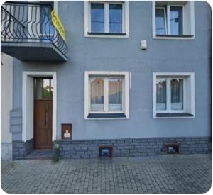 a blue building with a door and a balcony at Apartament Twin I in Żywiec
