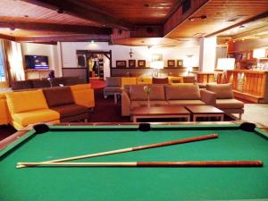 a pool table with two cuesticks in a living room at Hotel Ivalo in Ivalo