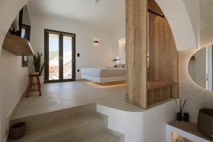 a bedroom with a bed and a staircase in a room at Ios Panoramic Sea view stylish suite with pool in Tzamaria