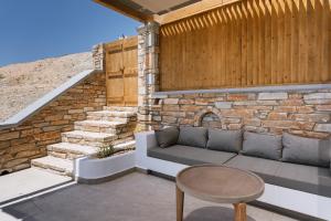 a patio with a couch and a table and stairs at Ios Panoramic Sea view stylish suite with pool in Tzamaria