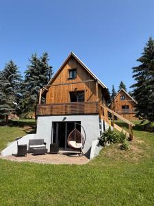 a large house with a porch with a bench and a house at Natka a Ratka in Louka
