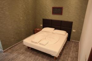 a bedroom with a bed with white sheets and pillows at Agora Apartments in Dhërmi