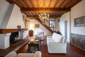 a living room with white furniture and a fireplace at Agriturismo Poggio Nardini in Montelupo Fiorentino