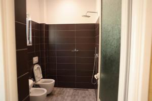 a small bathroom with a toilet and a sink at Agora Apartments in Dhërmi