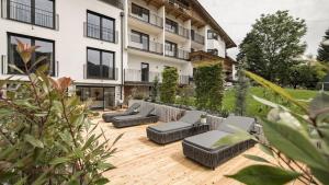 a patio with couches and chairs in front of a building at apartments '43 in Reith im Alpbachtal