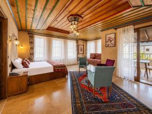 a bedroom with a bed and a desk in a room at Cappadocia Elite Stone House in Göreme