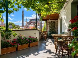 a patio with tables and flowers and a mosque at Anadolu Hotel in Istanbul