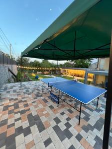 a blue ping pong table with a green canopy at Гостевой дом in Oganavan