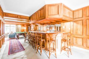 a kitchen with wooden cabinets and a bar with stools at Bryanston stays in Johannesburg