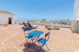 a patio with a blue table and chairs on a roof at Marbella Village in Marbella