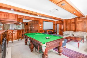 a game room with a pool table and a screen at Bryanston stays in Johannesburg