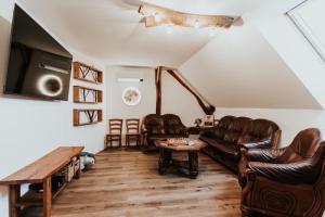 a living room with leather furniture and a flat screen tv at RANČ JUREŠ - Relaxing Countryside Escape in Ljutomer