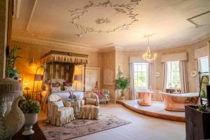 a large room with a bed and a bath tub at Pylewell Park House in Lymington